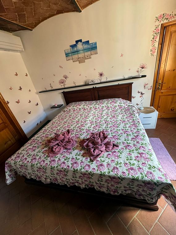 Camera Rosa: letto matrimoniale con copriletto a rose sotto la volta in cotto